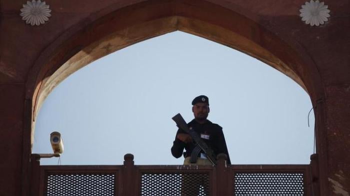 A police officer is framed by the architecture of Lahore's Badshahi Mosque while standing guard during a prayer session on Eid al-Adha November 7, 2011. Copyright Reuters