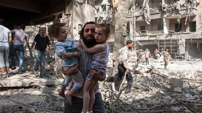 Syrian Man Carries Children After Barrel Bomb Attack