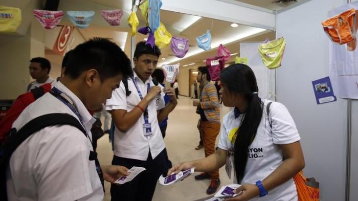 Students receive free condoms at an event organized by the United Nations Population Fund in Mandaluyong, Metro Manila, July 11, 2014.