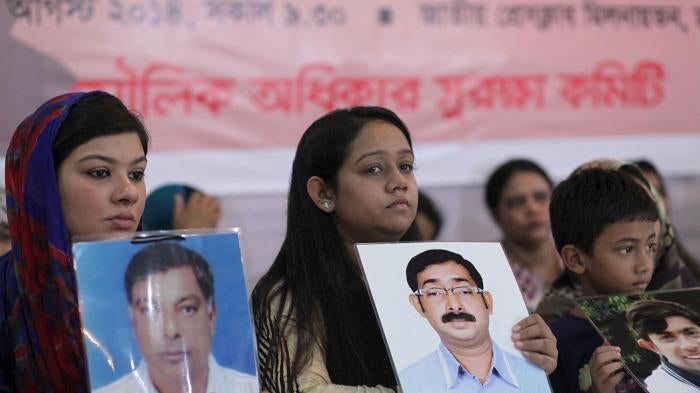 Relatives hold portraits of disappeared family members at an event calling for the end of enforced disappearances, killings, and abductions, in Dhaka, Bangladesh, August 30, 2014. 