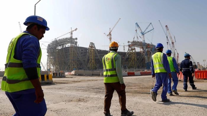 Workers walk towards the construction site of the Lusail stadium which will be build for the upcoming 2022 Fifa soccer World Cup during a stadium tour in Doha, Qatar, December 20, 2019. 