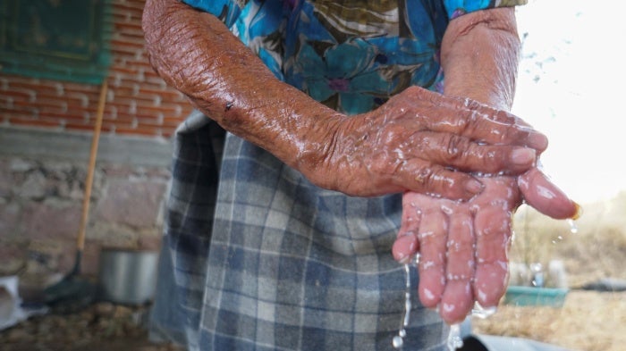 A Zapotec woman washes her hands after learning from a local radio program about hand-washing and social distancing to avoid COVID-19, in Oaxaca state, Mexico, March 31, 2020. 