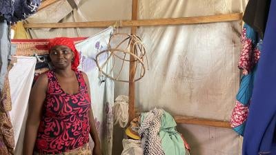 A woman stands inside a tent