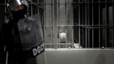 Um migrante venezuelano supostamente ligado a organizações criminosas sentado dentro de uma cela no CECOT em 16 de março de 2025, em Tecoluca, El Salvador.