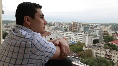 Man looking out over the balcony. 