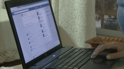A picture of a Palestinian activist scrolling through Facebook.