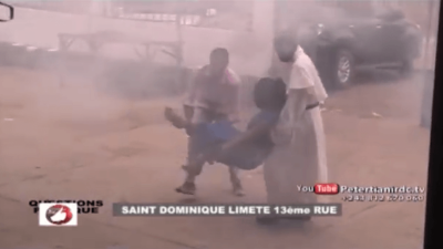 Photo of two people carrying a woman injured in the Democratic Republic of Congo.