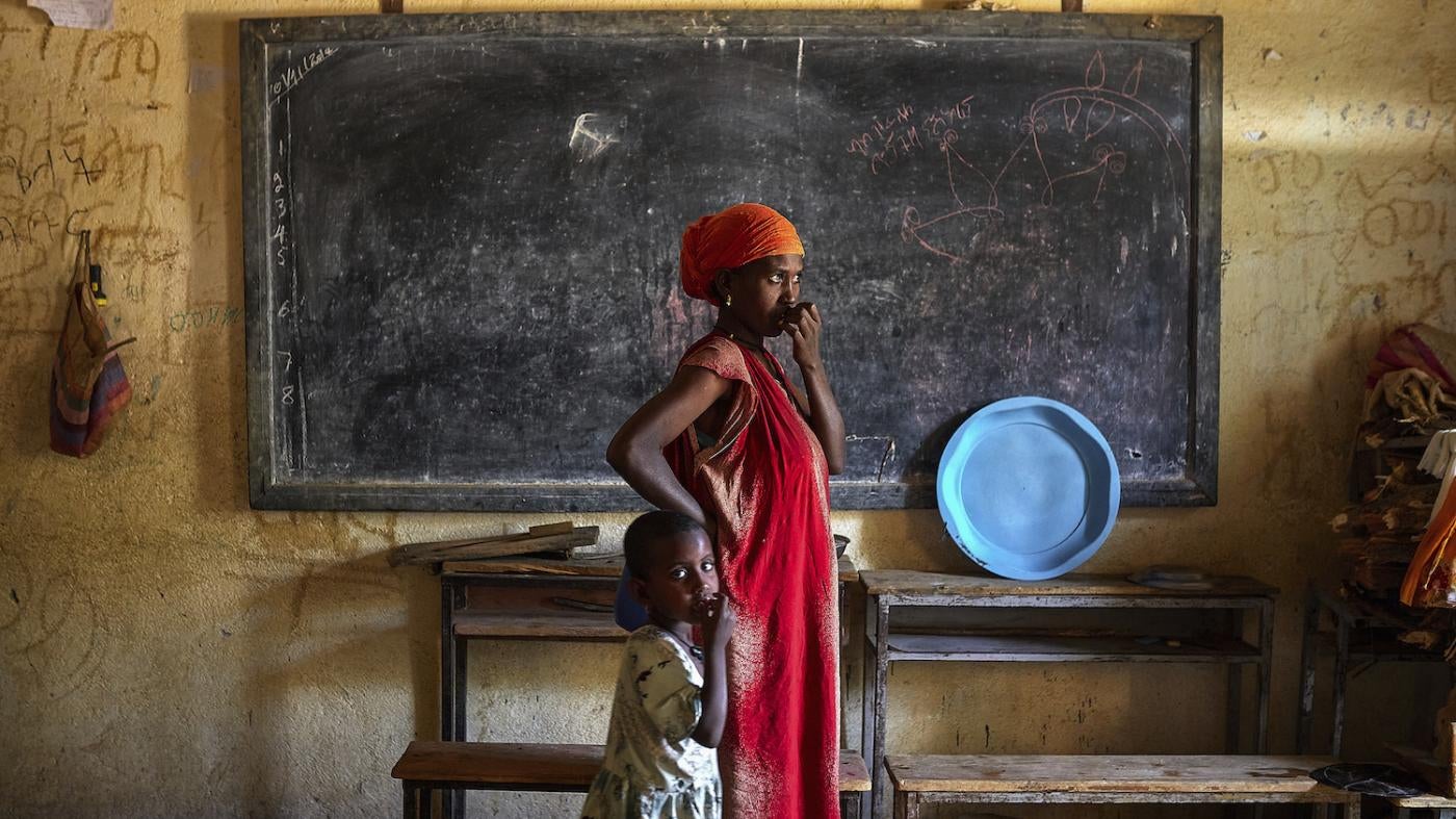 A woman looks out onto the street with her daughter inside a center for internally displace people in Abiy Adi, Tigray, Ethiopia, August 14, 2023. 