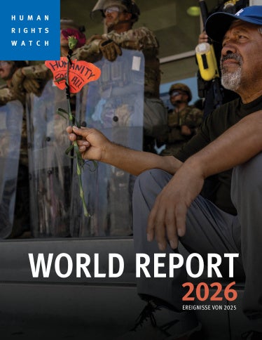 ein Mann hält ein Schild auf dem Steht "Menschlichkeit für alle"