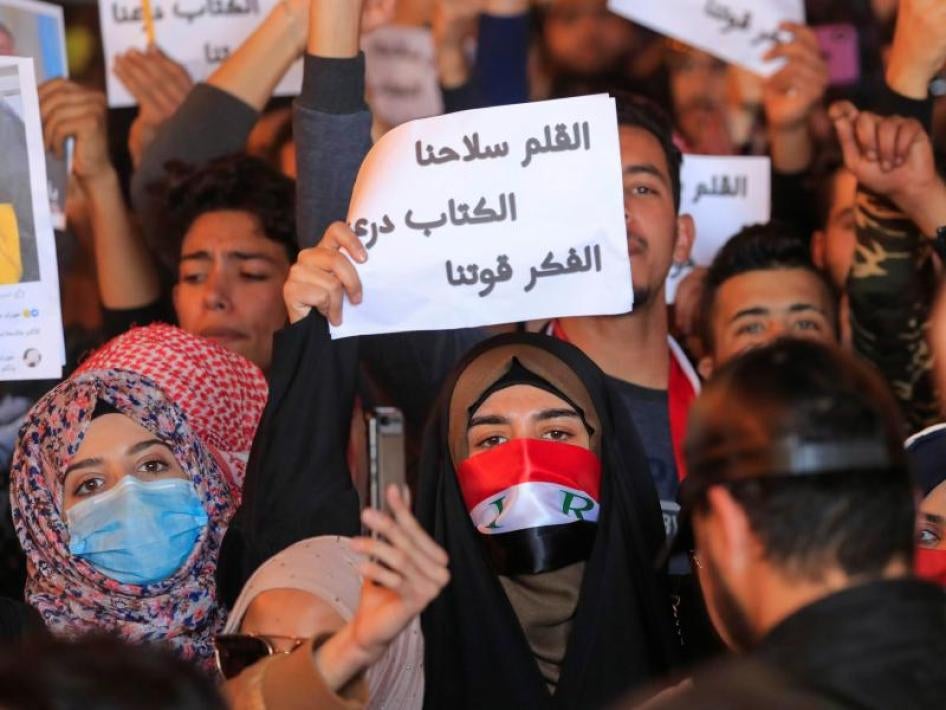 a woman holding up a sign during a protest