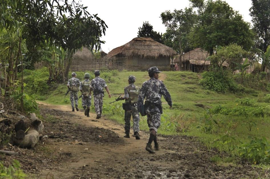 Myanmar border guard police officers walk along a path in Tin May village in northern Rakhine State, Myanmar, July 14, 2017.