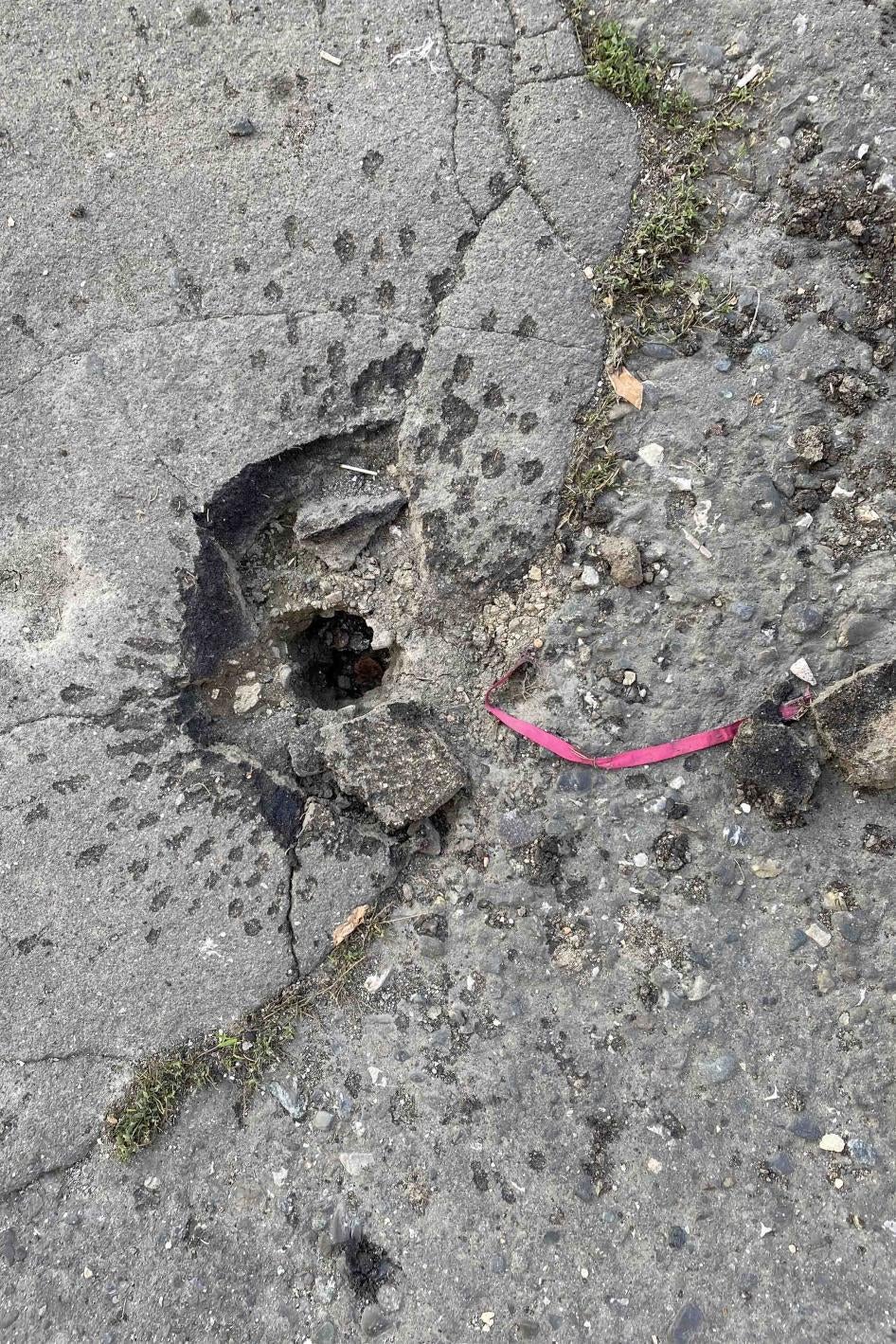 Характерные следы разрыва суббоеприпаса М095 и розовая стабилизационная лента рядом со зданием Карабах Телекома в Степанакерте 