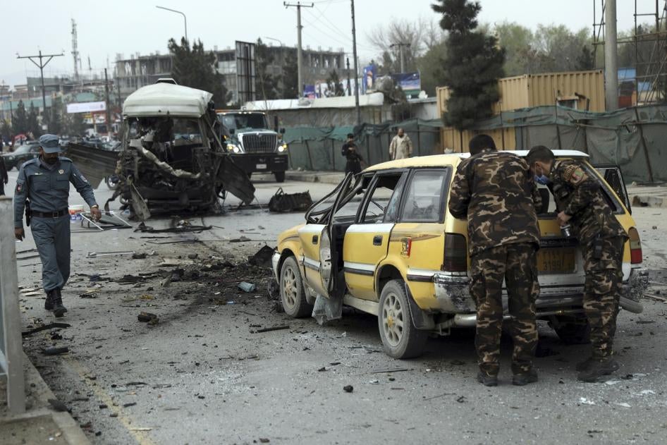 Security personnel inspect the site of a bomb attack in Kabul, Afghanistan on Monday, March 15, 2021. 