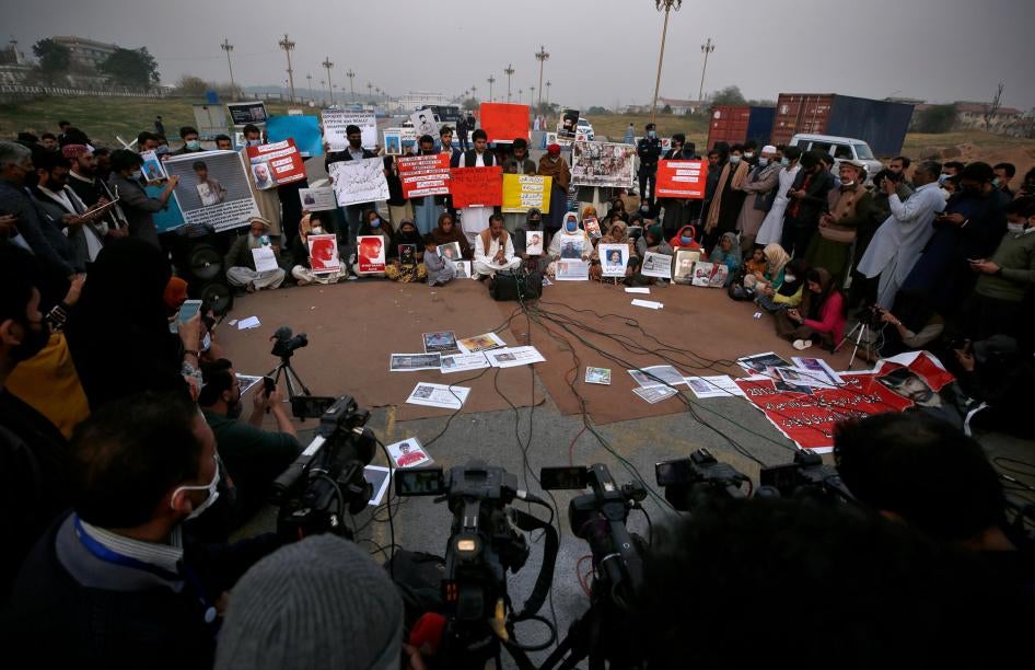 People hold placards and portraits of their missing family members during a press conference in Islamabad, Pakistan, February 20, 2021. 