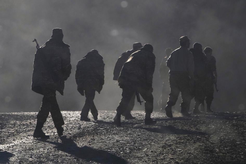 Ethnic Armenian soldiers walk along the road near the border between Nagorno-Karabakh and Armenia, Sunday, Nov. 8, 2020.