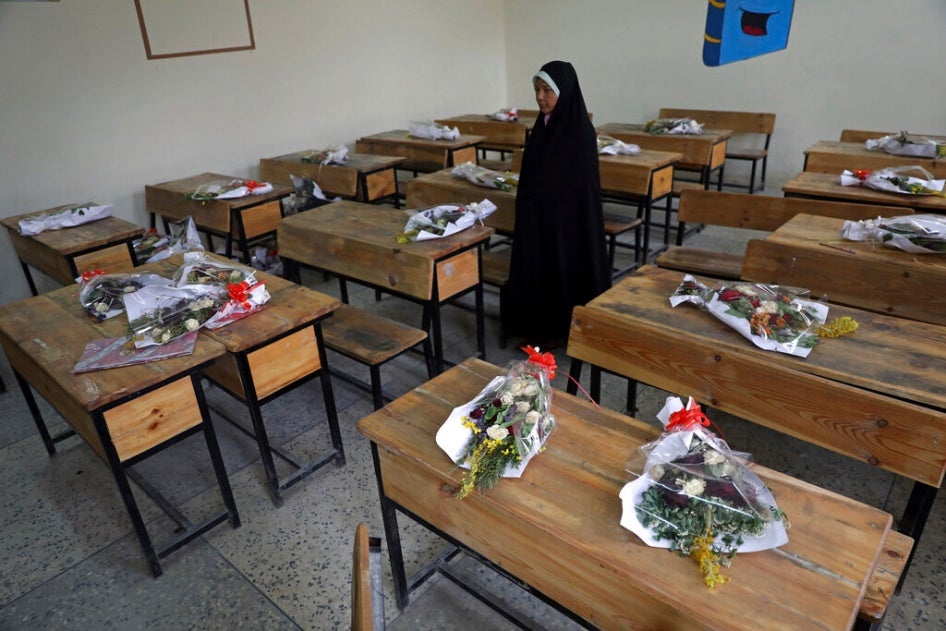 The mother of a schoolgirl who was among those killed in the brutal May 8, 2021 bombing of the Sayed ul-Shuhada girls' school stands inside a classroom with bouquets of flowers on empty desks as a tribute to the dead, in Kabul, Afghanistan, May 16, 2021. 