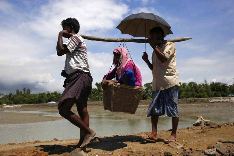Rohingya people refugees carry an older woman on the way to camp at Shahpori Island, in Teknaf, Bangladesh on September 13, 2017. 