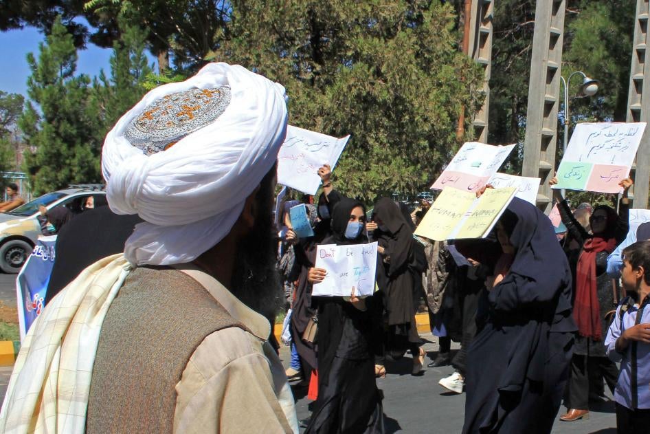 A Taliban member watches as women demonstrate for human rights in Herat, Afghanistan, September 2, 2021. 