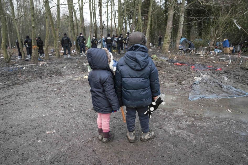 Deux enfants regardent la police saisir leur tente durant l’expulsion d’un campement à Grande-Synthe, dans le nord de la France, le 21 janvier 2021.