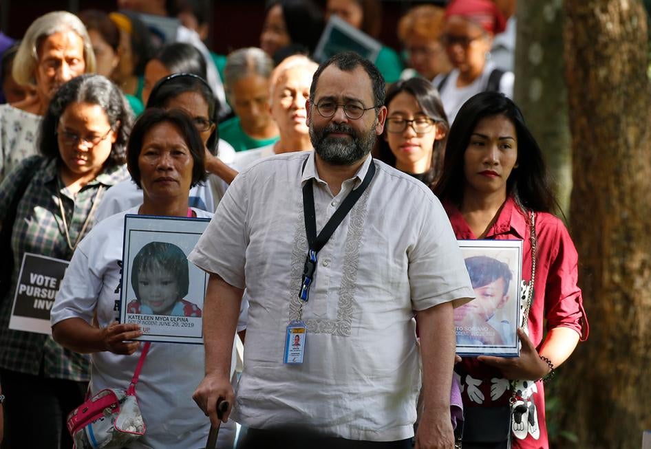 Commission on Human Rights Chair Chito Gascon, center, leads families of victims of alleged extrajudicial killings in the "war on drugs" in a march calling for an investigation by the UN Human Rights Council in Manila, Philippines, July 9, 2019.