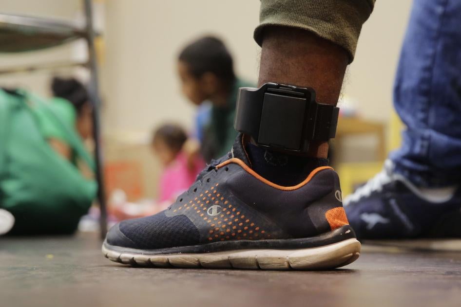 Close-up of a person wearing sneakers and an ankle monitor