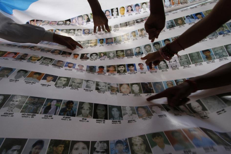 Nepalese human rights activists and relatives point to photographs of disappeared persons at an event to mark the International Day of the Disappeared, in Kathmandu, August 30, 2011. 