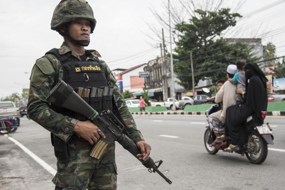 A uniformed police officer holding a gun next to a street