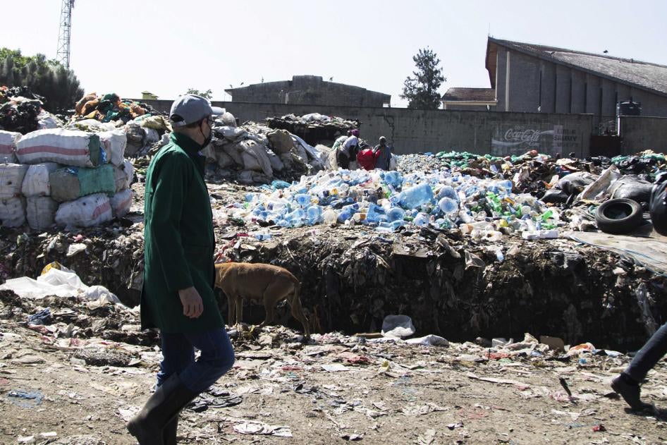 A man walks by a mound of plastic waste