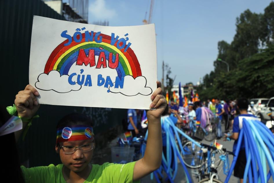 A cyclist holds up a poster reading in Vietnamese, "Shine your true colors," ahead of a bike rally in Hanoi, Vietnam, September 24, 2017. 