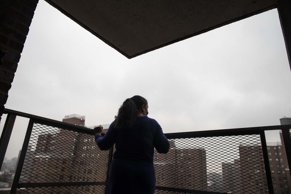 A woman looks out at a city from a patio