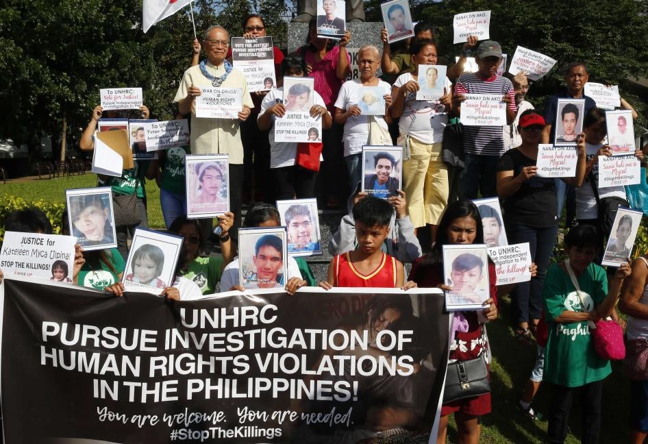 Families of victims of extrajudicial killings in the "war on drugs" display portraits of their slain relatives and call on the UN Human Rights Council to investigate the killings, in Quezon City, Philippines, July 9, 2019.
