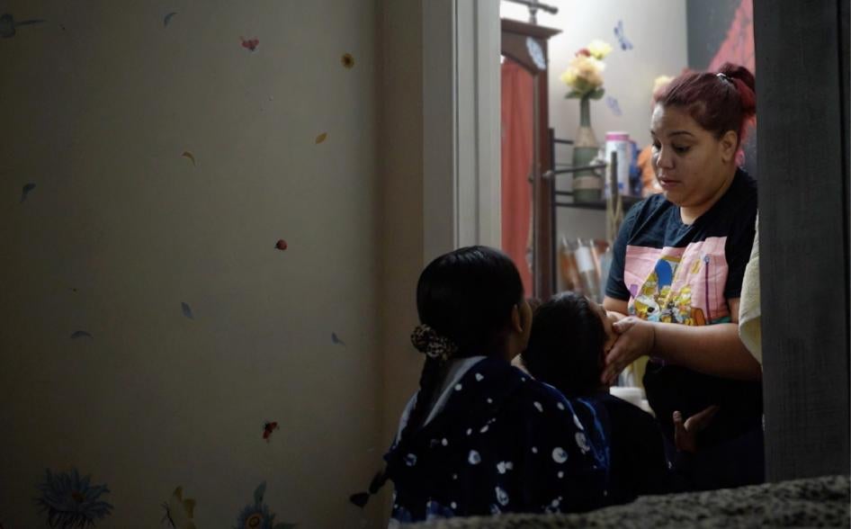 A woman holds her childs face