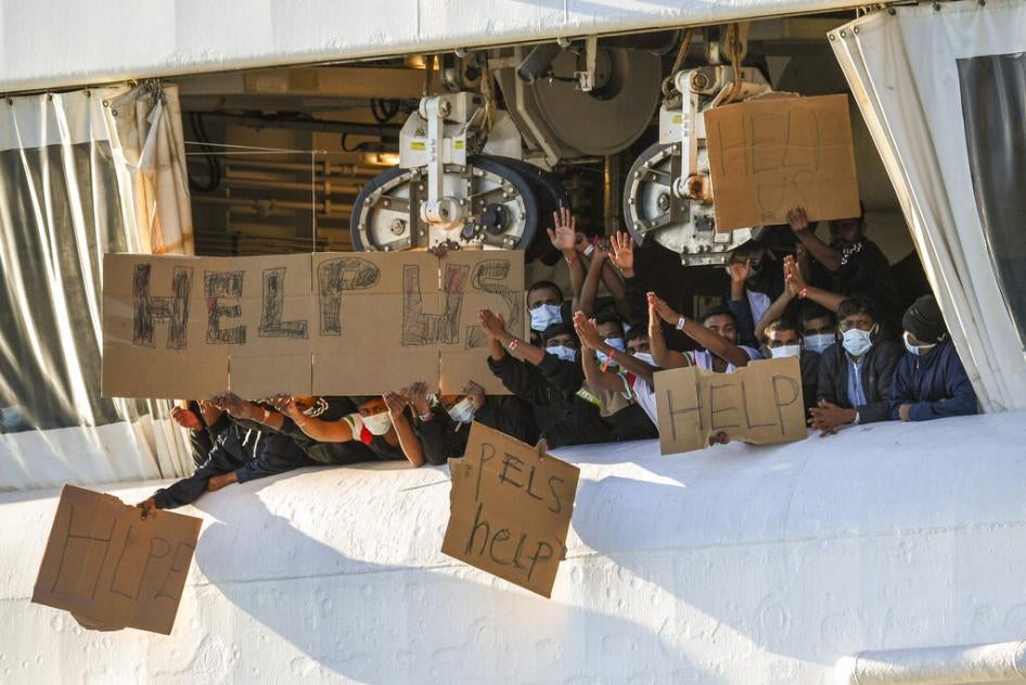 Des migrants secourus en Méditerranée par le navire de sauvetage Geo Barents, affrété par Médecins sans frontières et accosté dans le port sicilien de Catane, près de la côte sud de l'Italie, tenaient des pancartes appelant à l'aide, le 7 novembre 2022. Ils attendaient l’autorisation de débarquer.