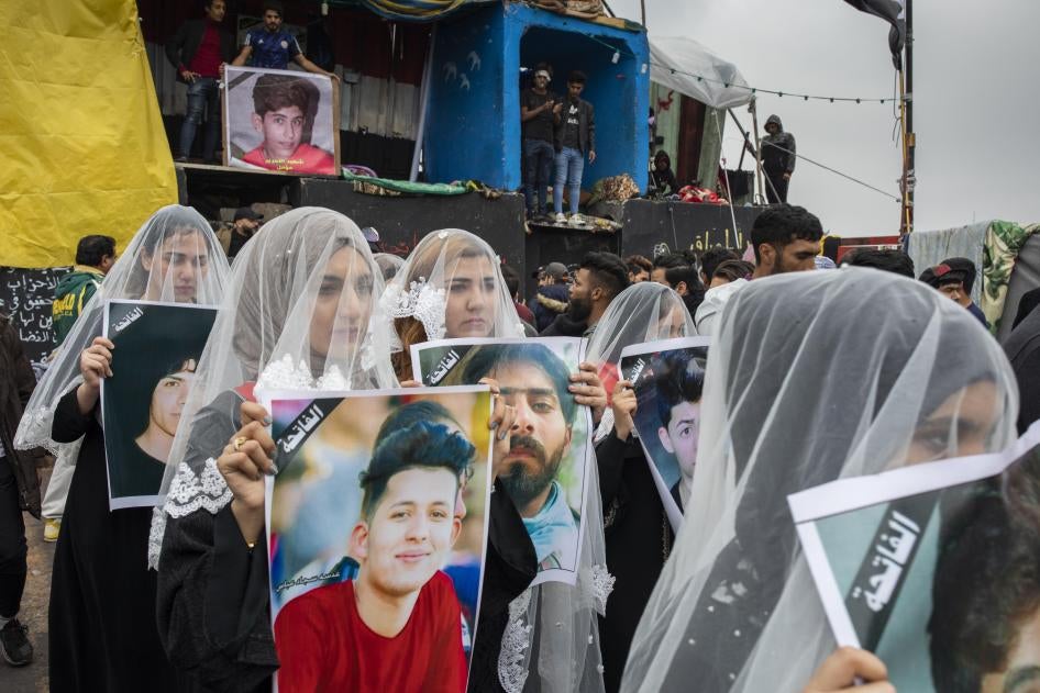 Des femmes irakiennes voilées portaient des photos de manifestants tués durant les premières semaines du mouvement protestataire « Tashreen&nbsp;» (« octobre&nbsp;») ayant débuté en octobre 2019, lors d’un rassemblement sur la place Tahrir à Bagdad en décembre 2019.n