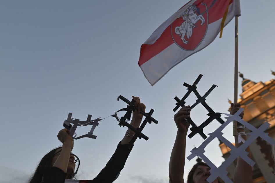 Protesters display broken paper prison bars representing the Belarusian population in prisons and the lack of freedom in Belarus, in Krakow, Poland on August 9, 2022. 