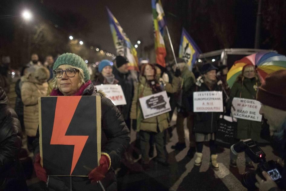 Woman holds a Women's Strike symbol during protest against what they view as an erosion of women’s rights under Poland’s conservative ruling party, Warsaw, Poland, November. 28, 2022 