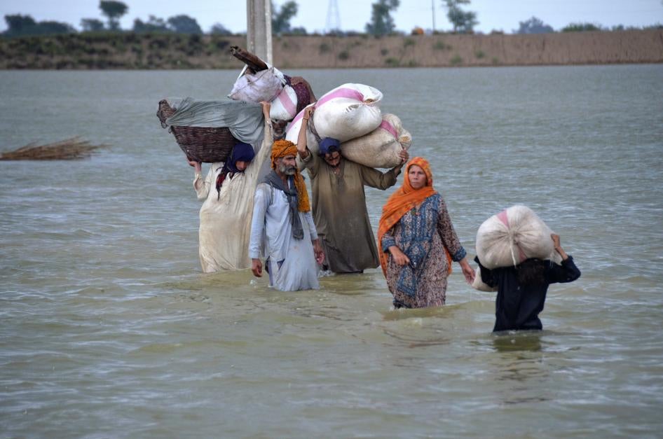 A displaced family wades through a flooded area after heavy rainfall in Jaffarabad, in Pakistan's southwestern Balochistan province.