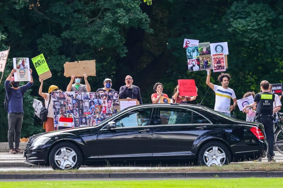 Protesters hold banners and chant slogans during Egyptian President Abdel Fattah al-Sisi’s official visit to Germany on July 18, 2022, in Berlin.