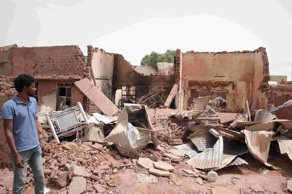 Man stands next to building destroyed during fighting in Khartoum, Sudan