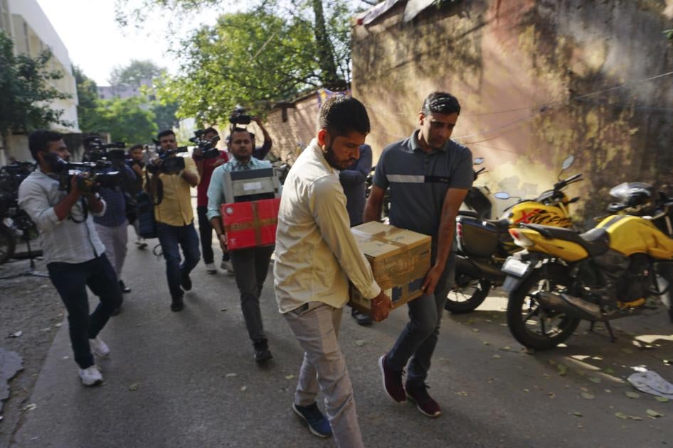 Security officers carry boxes of material confiscated after a raid at the office of NewsClick in New Delhi, India, October 3, 2023. 