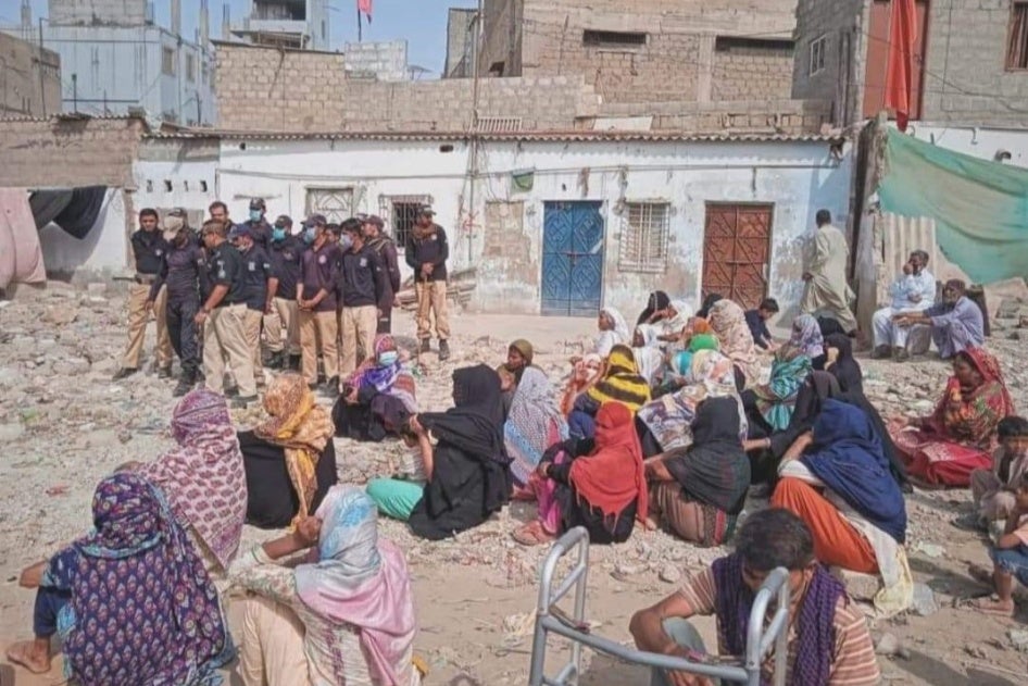 Women protest their eviction at a stormwater drain