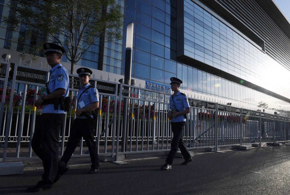 Police officers patrol outside the China National Convention Center in Beijing, May 13, 2017. (