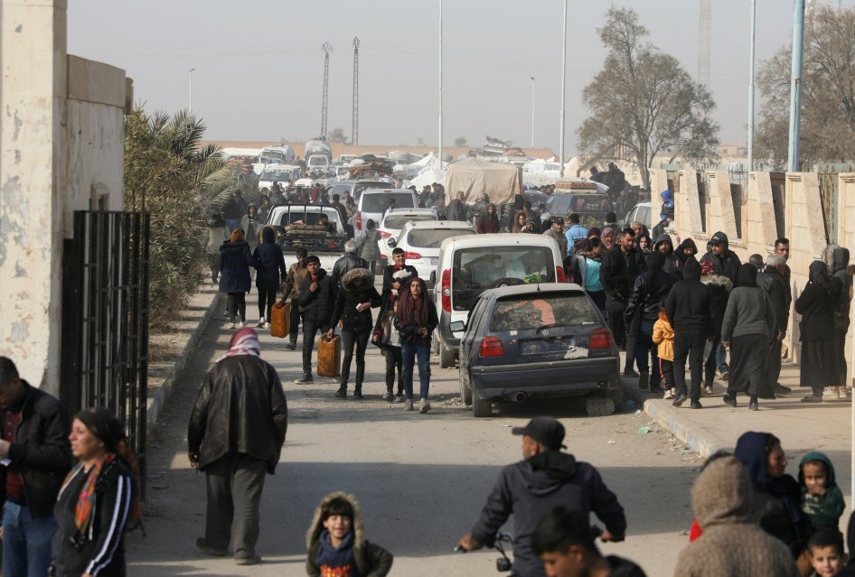 Displaced people who fled the Aleppo countryside walk in Tabqa, Syria, December 4, 2024. 