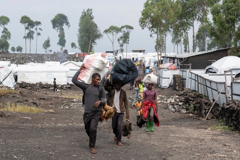 Des civils fuient le camp de déplacés de Nzulo vers Goma.