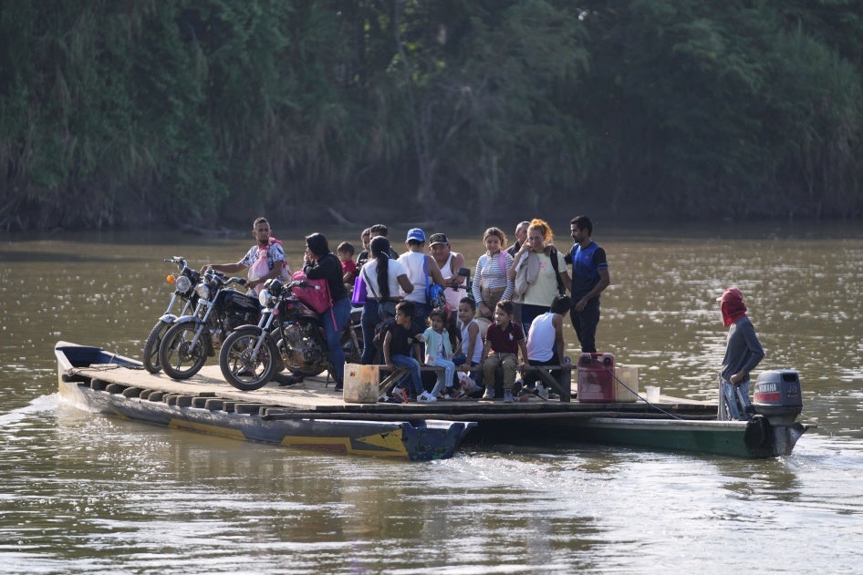 Menschen überqueren am 21. Januar 2025 einen Fluss von Tibu, Kolumbien, nach Venezuela, nachdem bei Kämpfen Dutzende getötet und Tausende gezwungen wurden, aus ihren Häusern in der kolumbianischen Region Catatumbo zu fliehen.