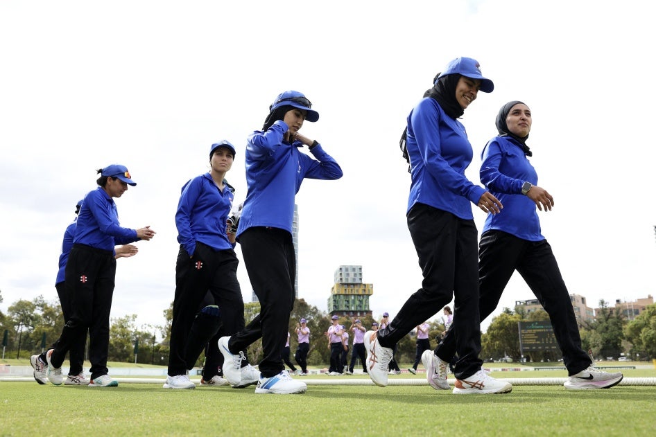 Afghan women cricket players prepare to take the field during the match between Afghanistan Women's XI and Cricket Without Borders XI in Melbourne, Australia, January 30, 2025.