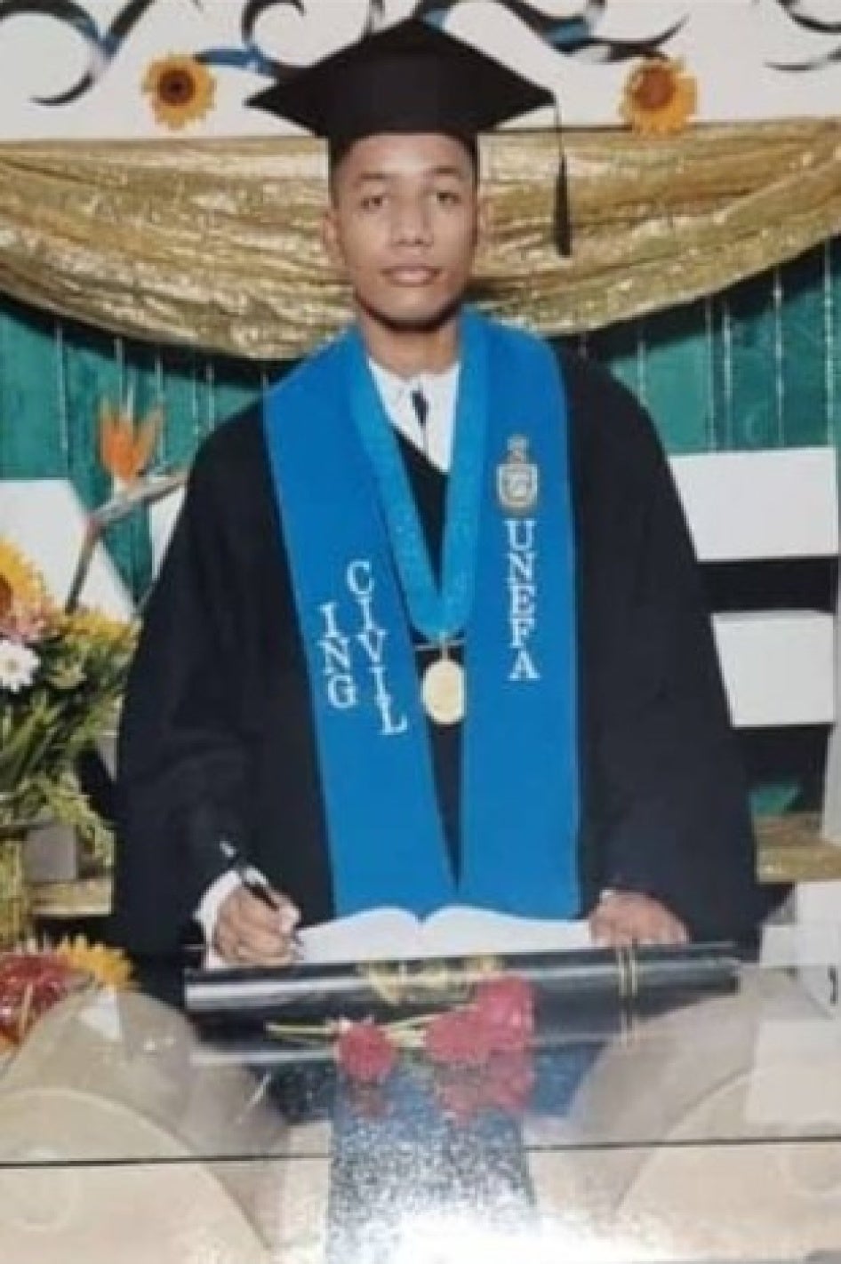 A young man wearing graduation robes