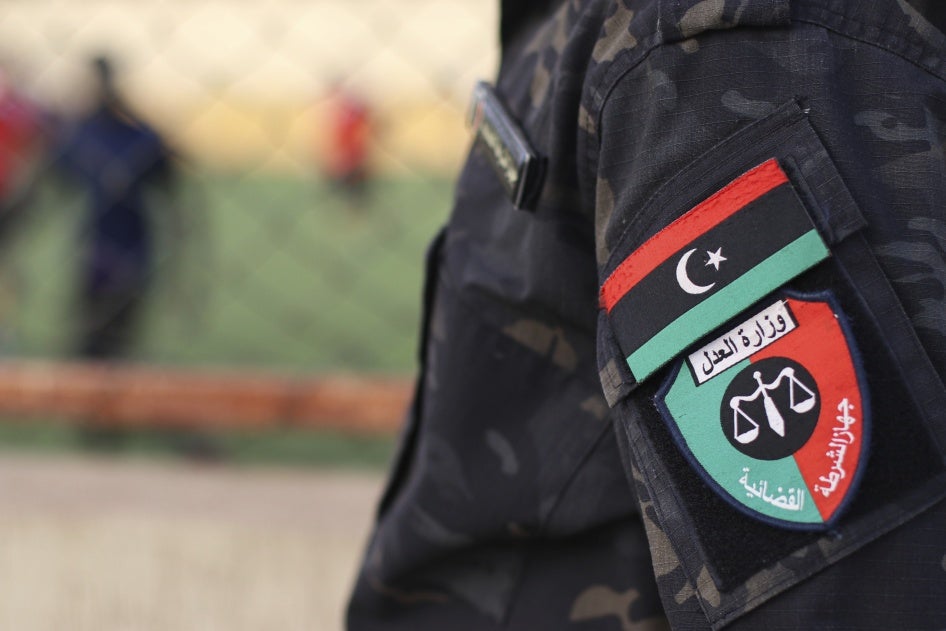 An emblem on the uniform of a judicial police guard standing at a prison