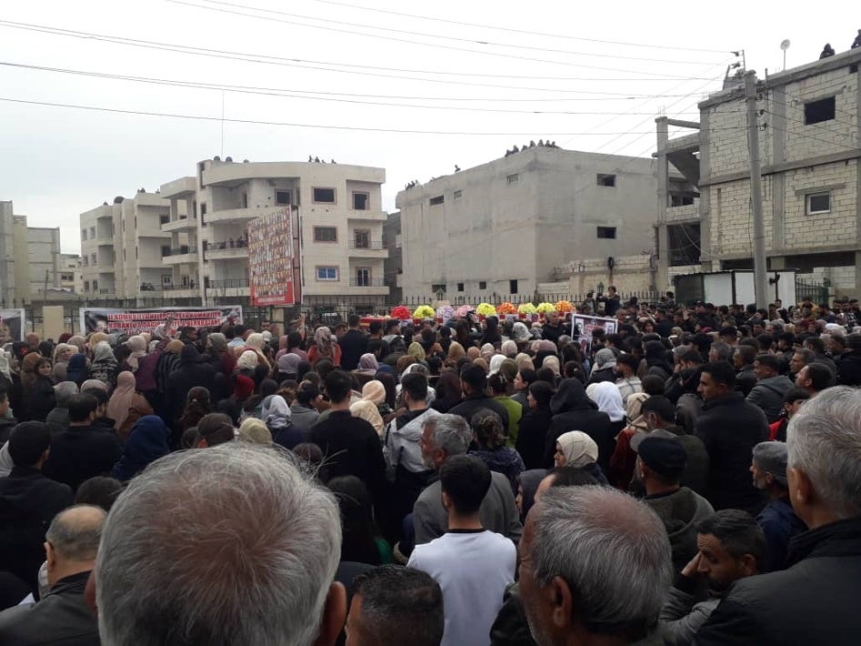 قرويون وسكان من كوباني متجمعون لدفن 10 أفراد من عائلة عبدو، الذين قتلوا جميعا في غارة بمسيّرة، في مارس/آذار 2025.