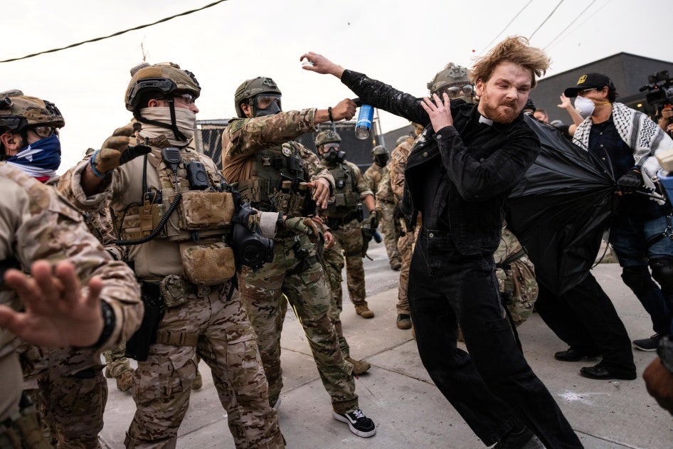 A federal immigration enforcement agent sprays Rev. David Black, of the First Presbyterian Church of Chicago, as he and other protesters demonstrate outside the US Immigration and Customs Enforcement facility in Broadview, Illinois, September 19, 2025.